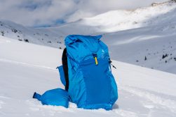 a blue backpack sitting on top of a snow covered slope.