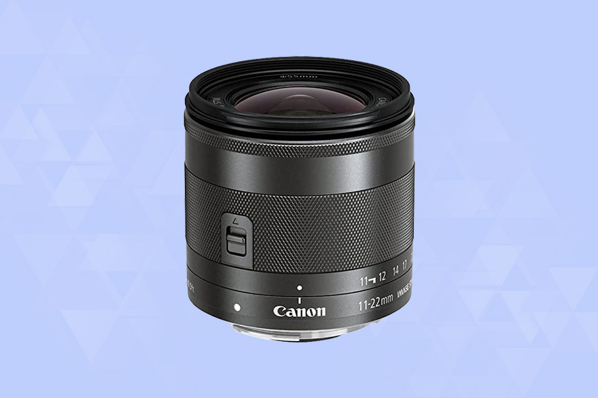 a Canon EF-M 11-22mm f/4-5.6 IS STM camera lens on a blue background.