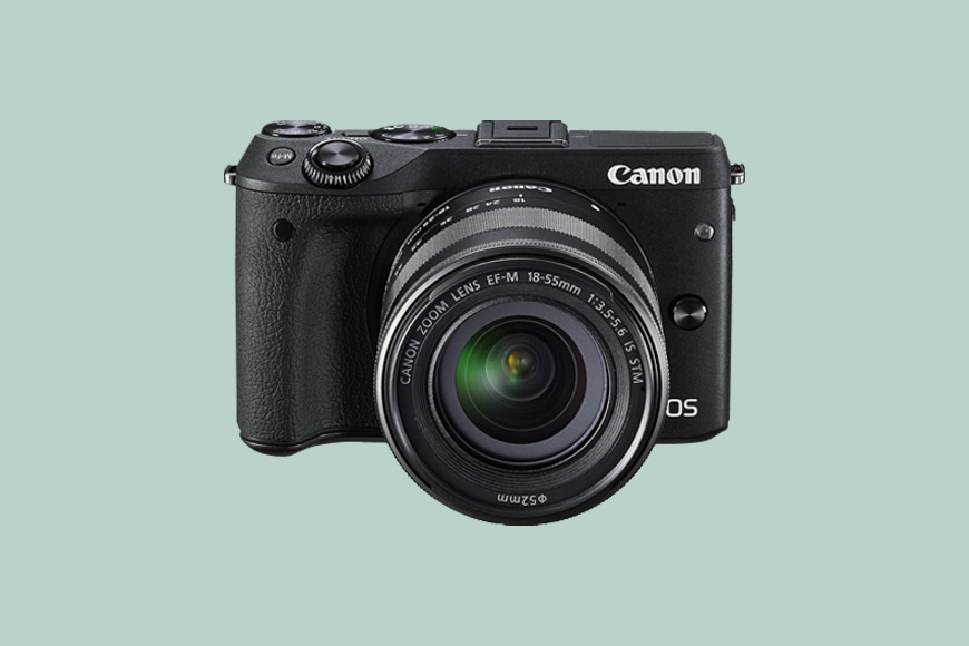 A Canon EOS M3 camera on a green back ground.