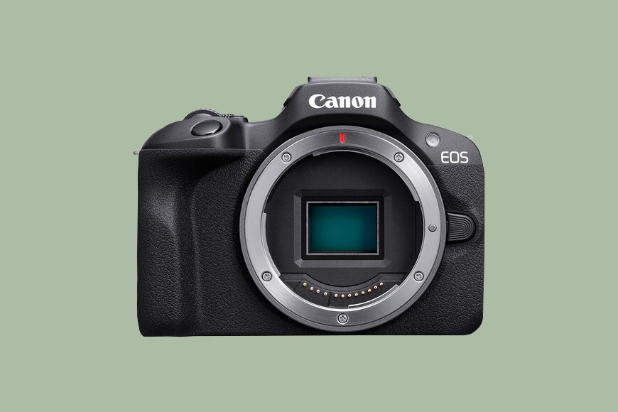 A Canon EOS R100 on a green back ground.