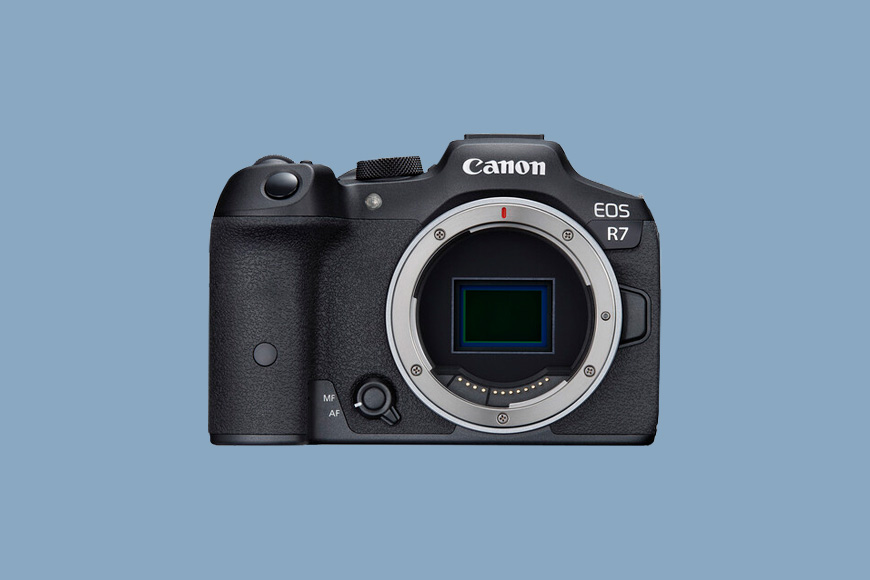 A Canon EOS R7 on a blue back ground.