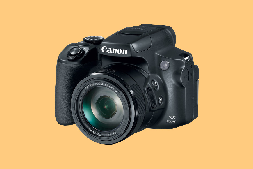 a Canon PowerShot SX70 HS camera with a yellow background.