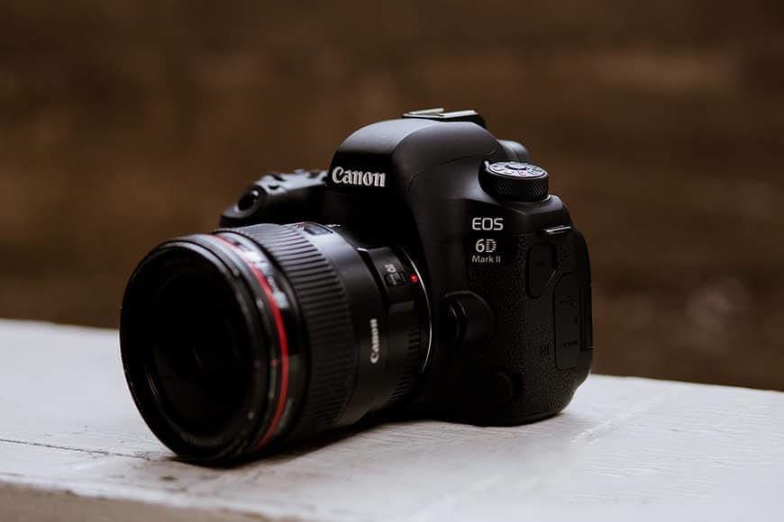 A Canon EOS 6D Mark II camera on a white painted timber plank.