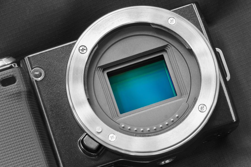 A black and white image of a camera with a blue lens.