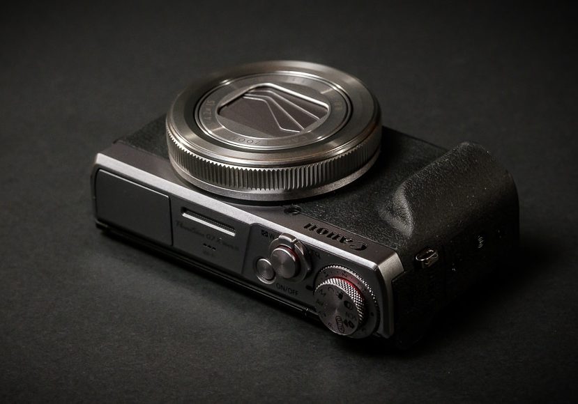 A Canon PowerShot G7 X Mark III camera on a black table.