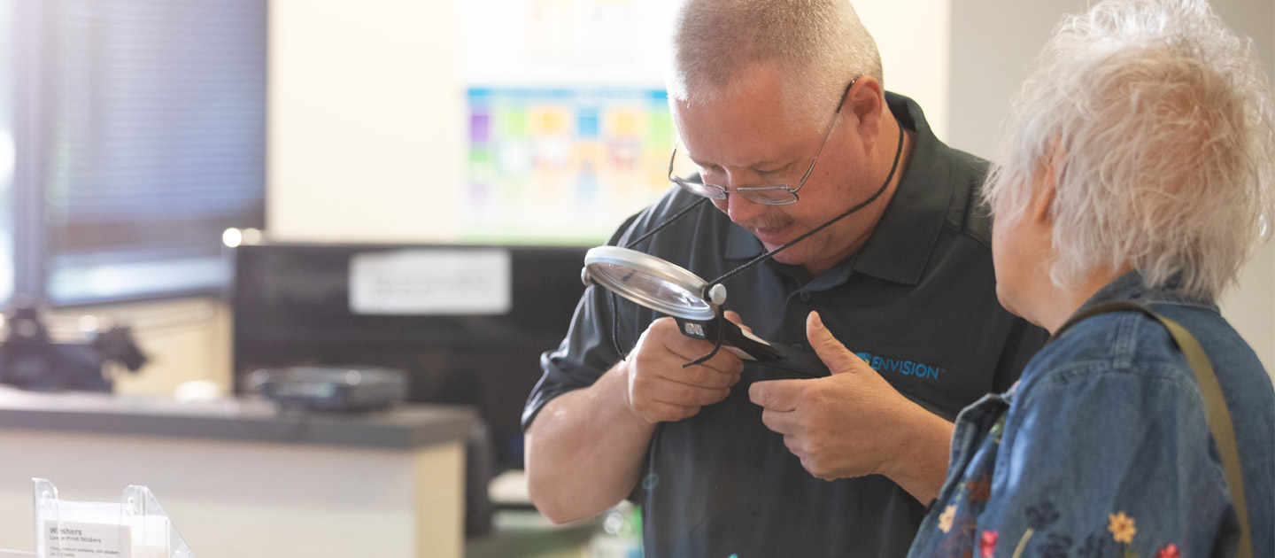 Assistance is given to a woman who is visually impaired at the Envision Everyday Store.