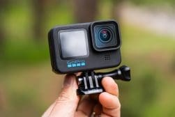 A person holding up a gopro hero 11 action camera.