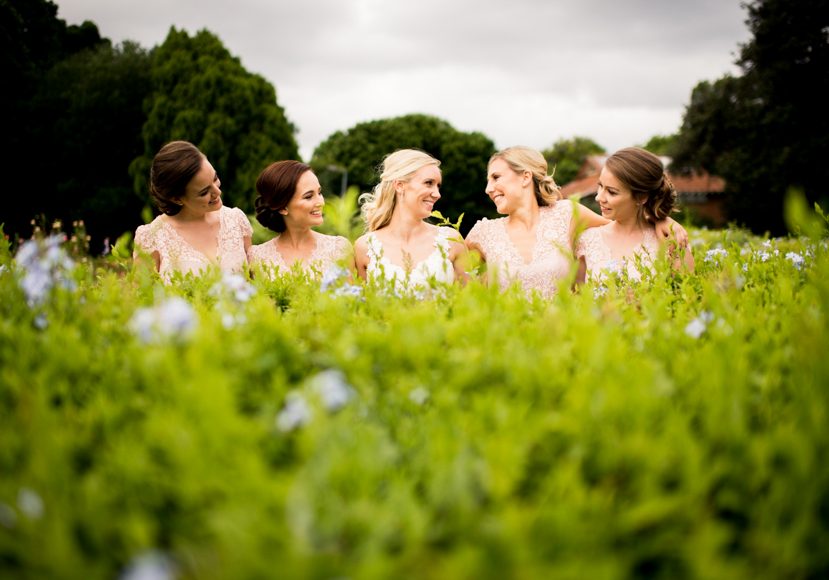 a group of bridesmaids in a field of flowers.