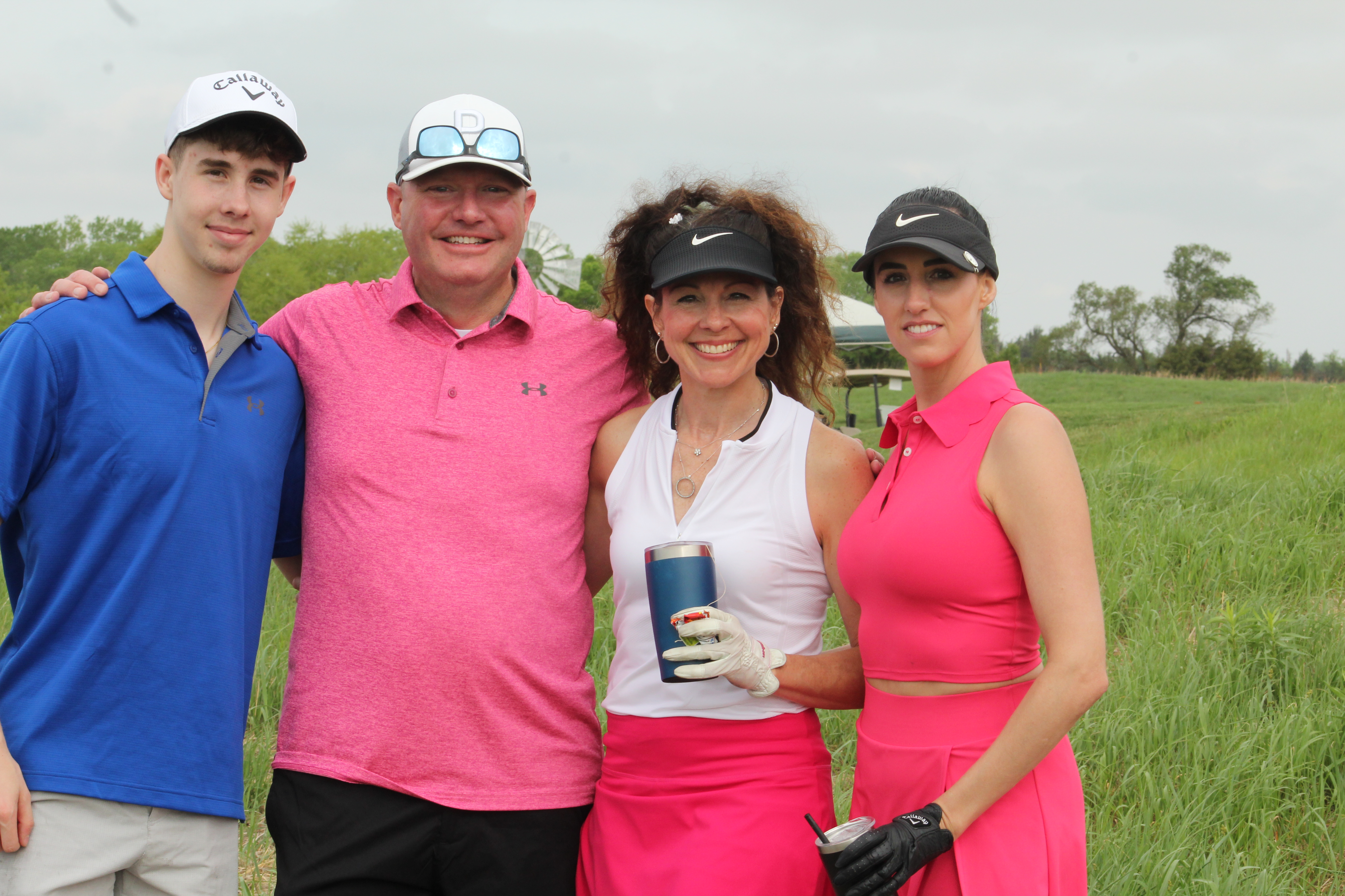 A group of four golfers smiling.