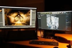 Two monitors on a desk showing Lightroom and RawRTherapee.