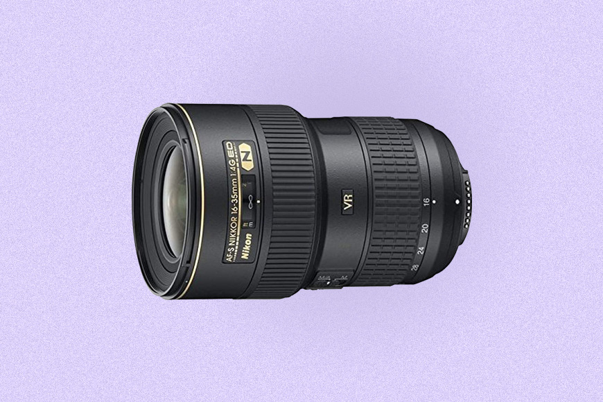 a close up of a Nikon camera lens on a purple background.