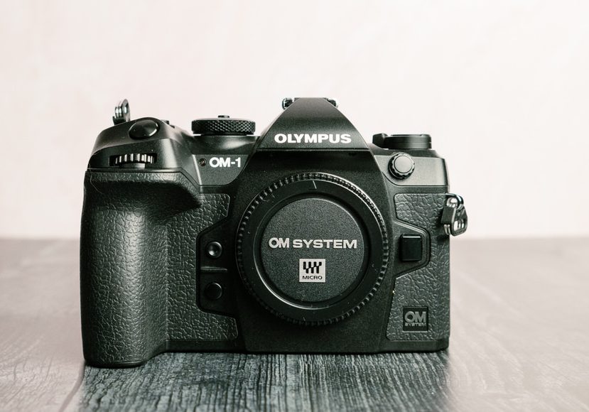 A OM System OM-1 camera on a black table