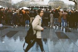 A woman walks through a crowd of people in paris.