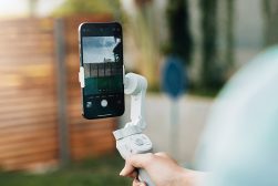 a person holding a smartphone gimbal and taking a picture.