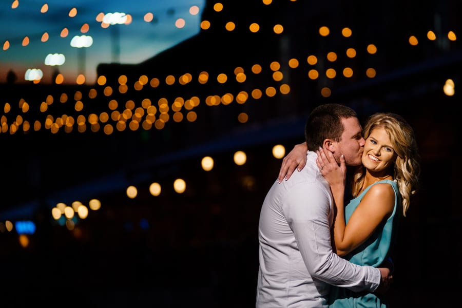 couple kissing under bokeh lights