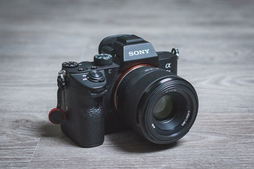 sony 50mm f/1.8 lens attached to a7III e-mount mirrorless camera on desk