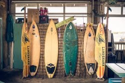 A group of surfboards leaning against a wall.
