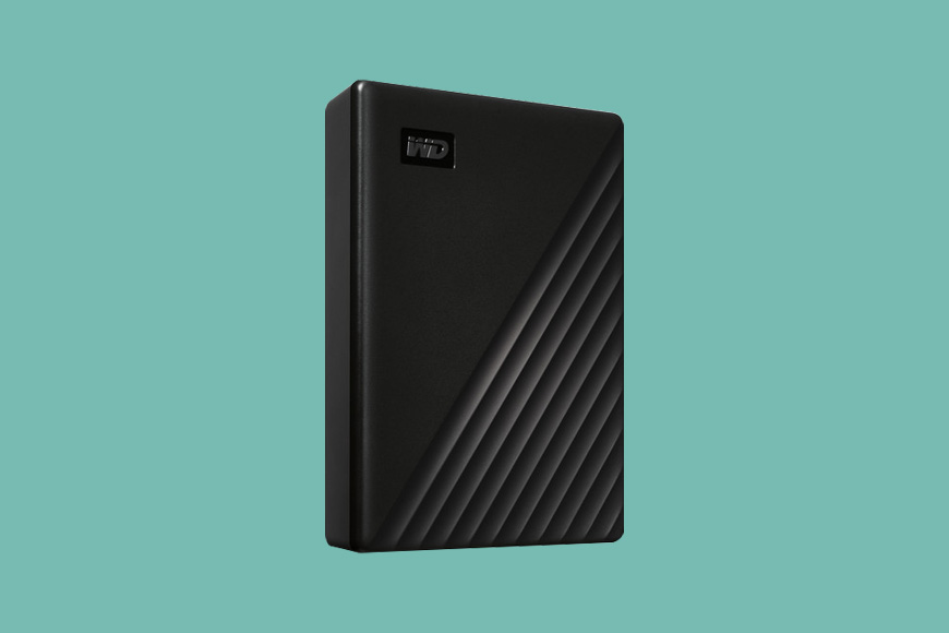 a black WD 5TB My Passport external hard drive on a green background.