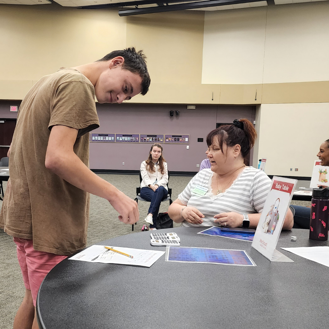 Terese sitting at a table teaching a level up student about family home health as a part of a Level Up activity..