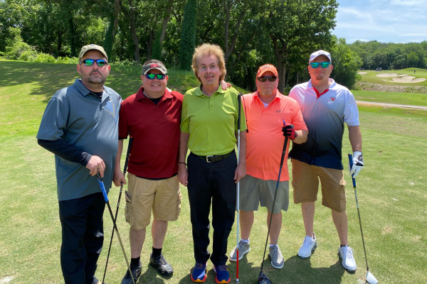 A group of 5 golfer smiling for the camera.