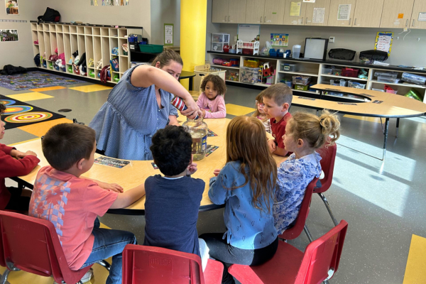 Sophia with 4H using shaving cream in a science experiment while children watch.